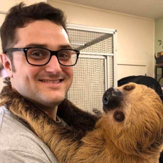 Photo of Luke holding a sloth